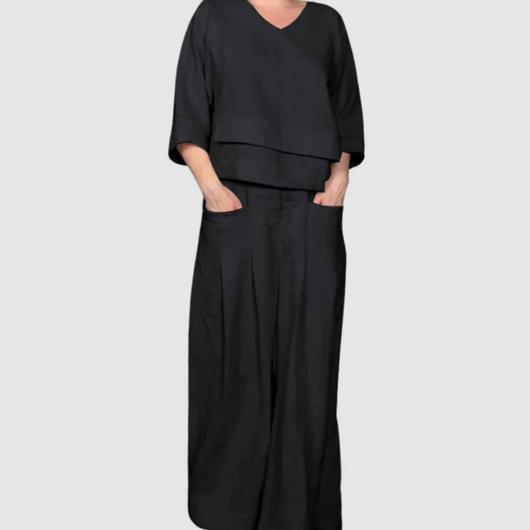 Black relaxed 2-piece set with V-neck top and wide-leg pants featuring pockets, studio background.