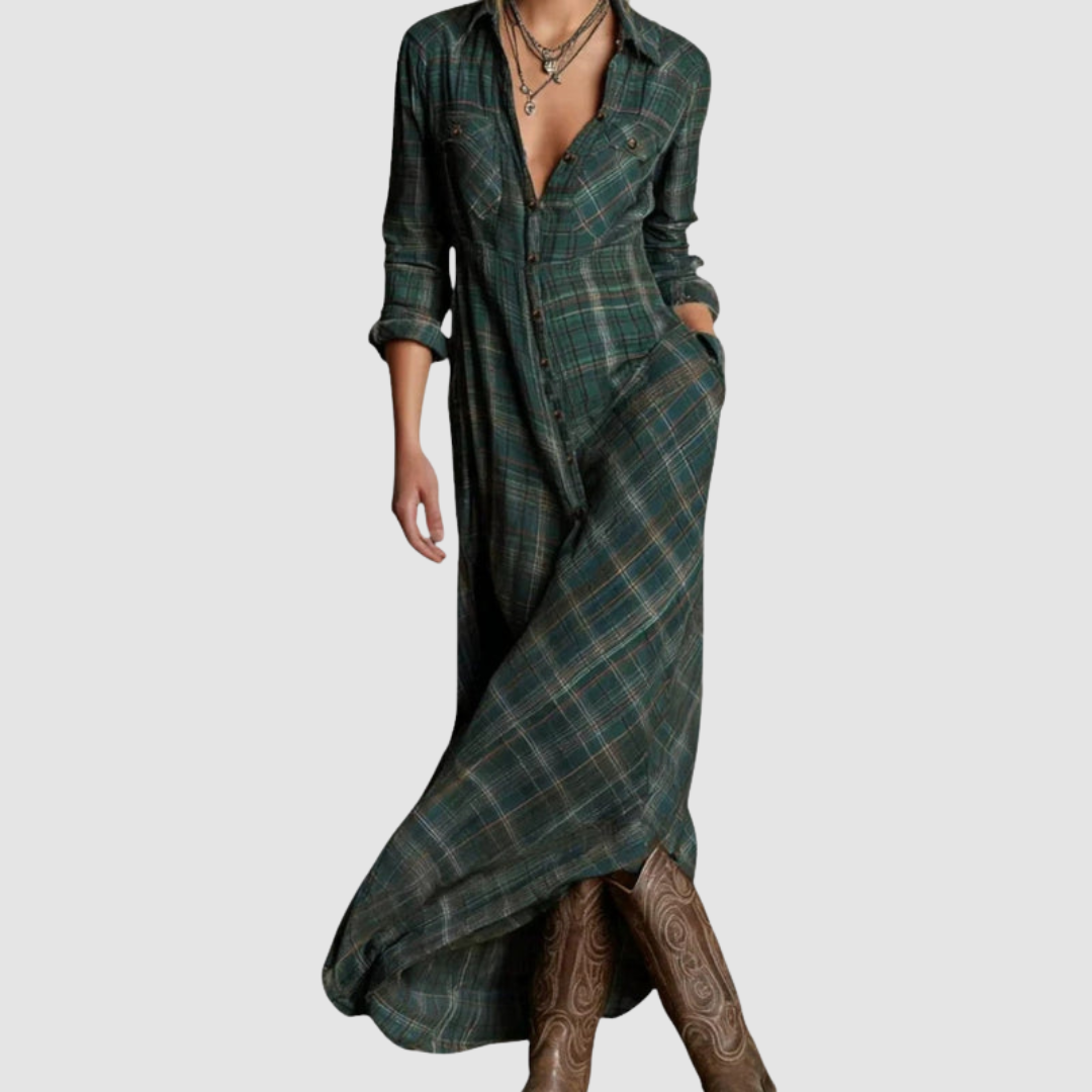 Model wearing a plaid long dress with rolled sleeves and button details, paired with knee-high boots, studio background.
