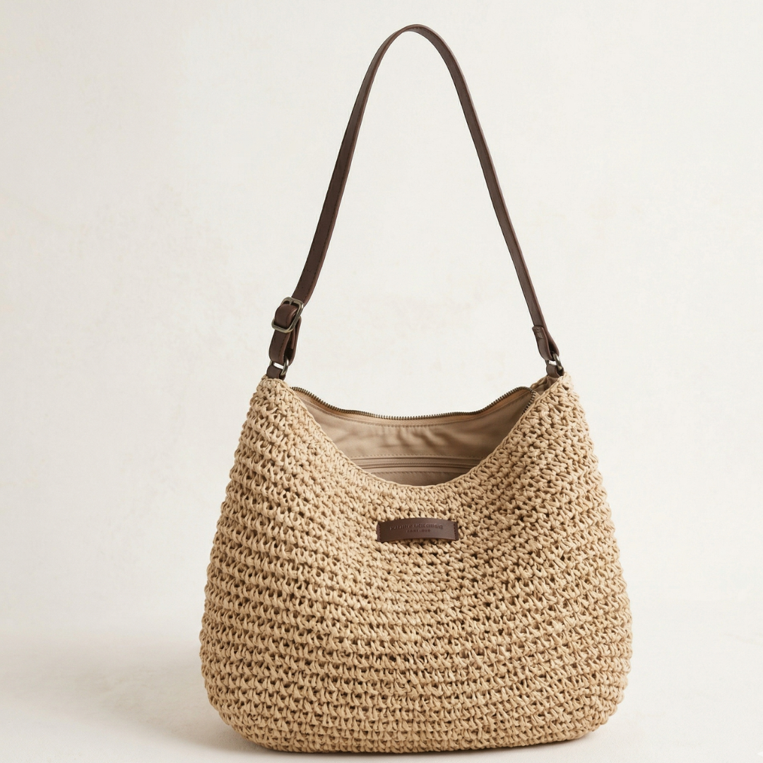 Elegant woven shoulder bag with brown strap in a neutral studio setting.