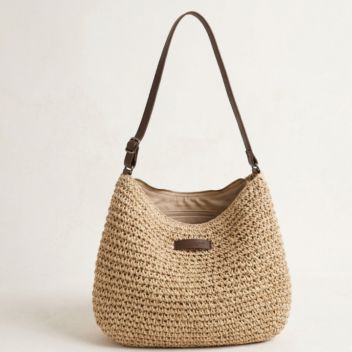 Elegant woven shoulder bag with brown strap in a neutral studio setting.