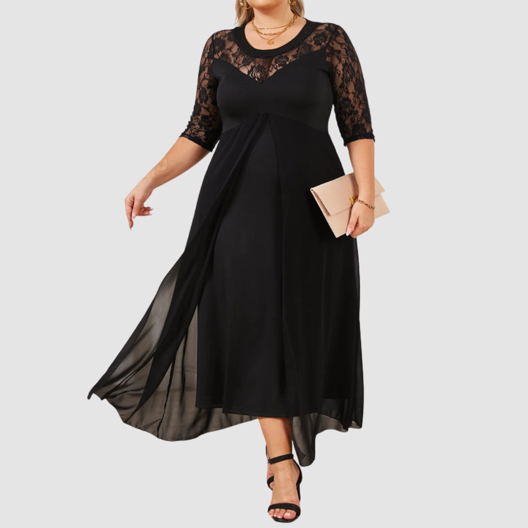 Flowing black dress featuring lace top, paired with beige clutch and strappy heels. Studio background.