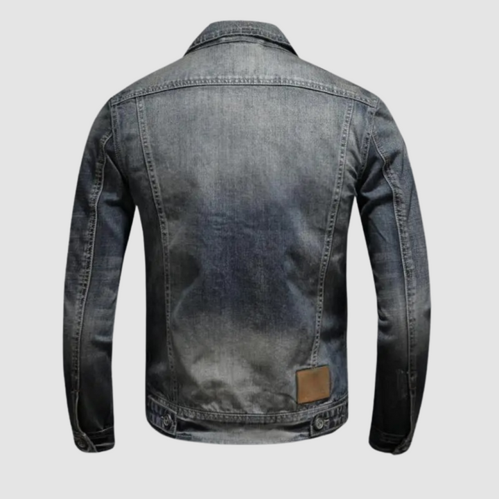 Back view of classic denim jacket showing stitching details on plain background.