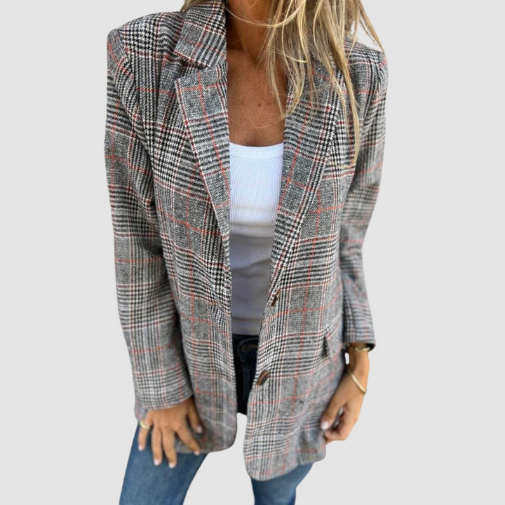 Plaid winter blazer in red and gray houndstooth pattern worn with white top and jeans in a studio setting.