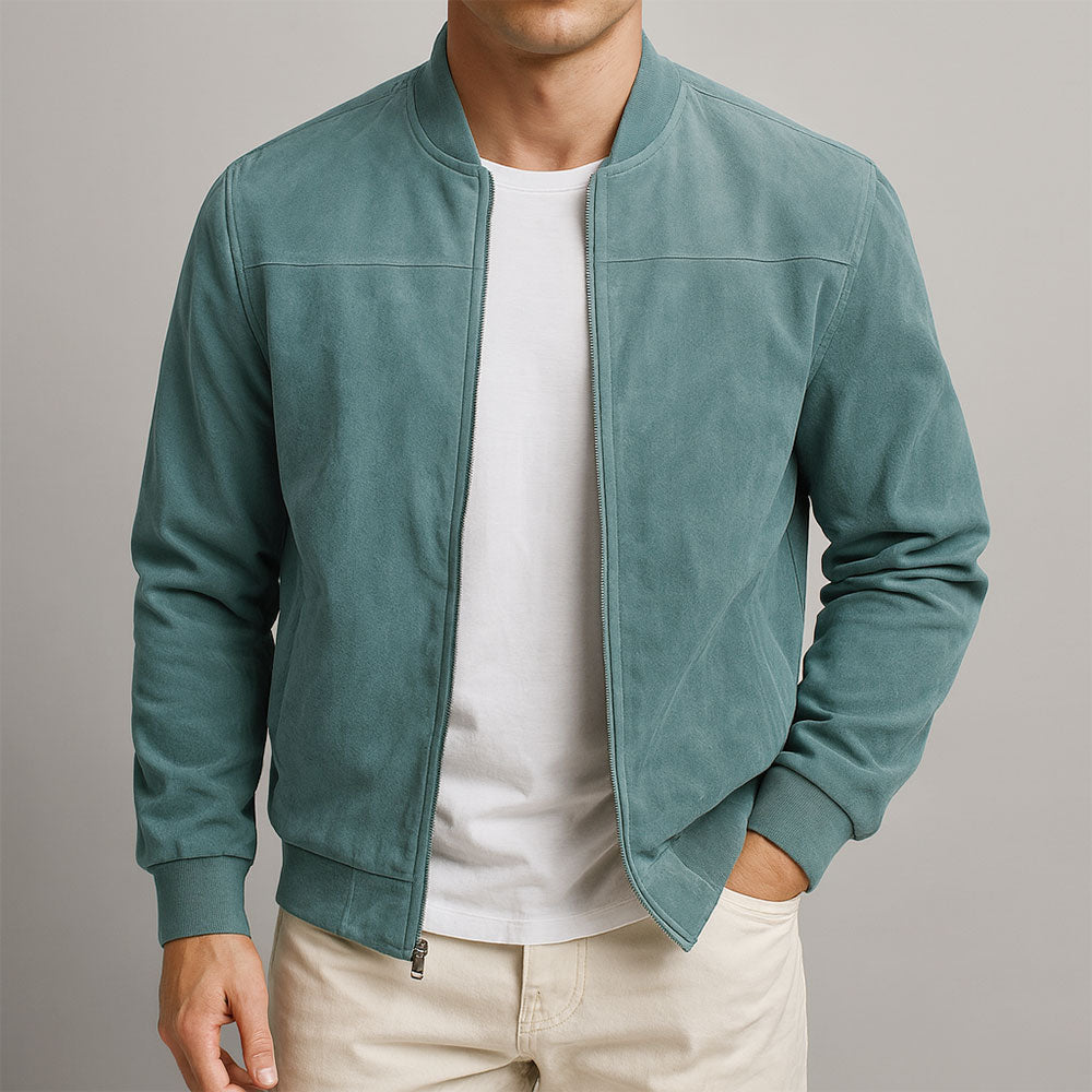 Man wearing a teal urban classic jacket, white shirt, and beige pants against a light background.