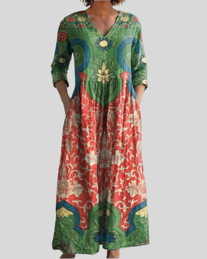Vintage floral long dress with colorful patterns, featuring green, red, and blue tones, studio background.