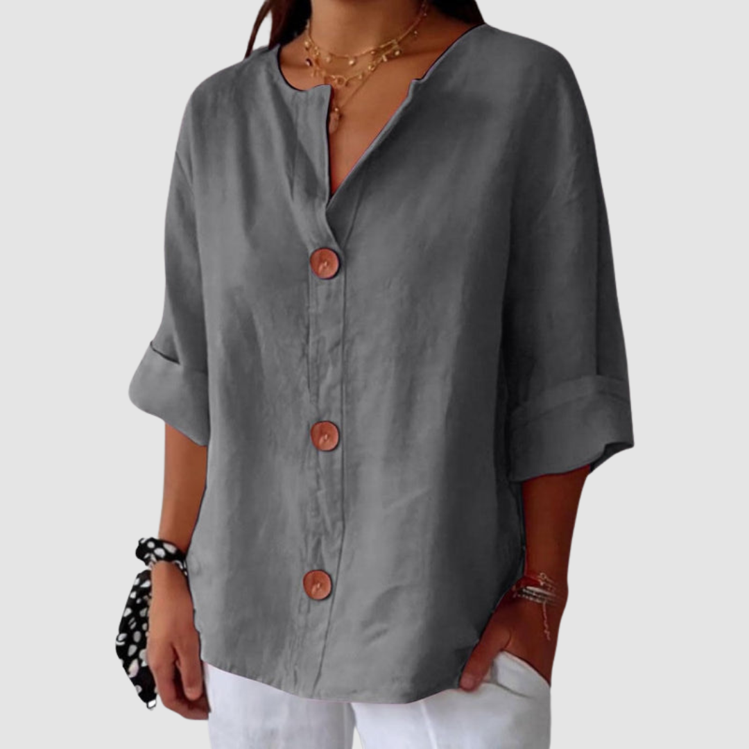 Gray casual blouse with large buttons, rolled-up sleeves, on a simple backdrop.