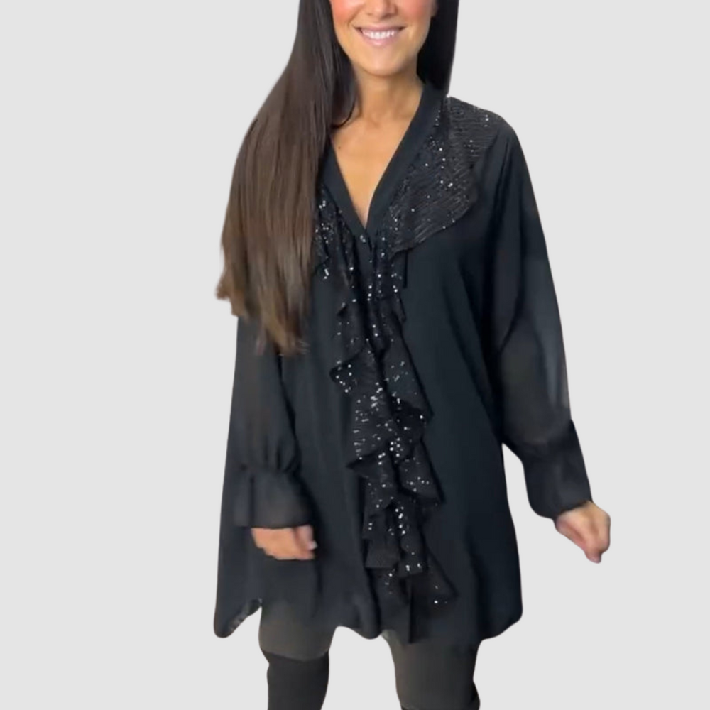 Black elegant blouse featuring sparkling ruffles, paired with leggings in a studio environment.