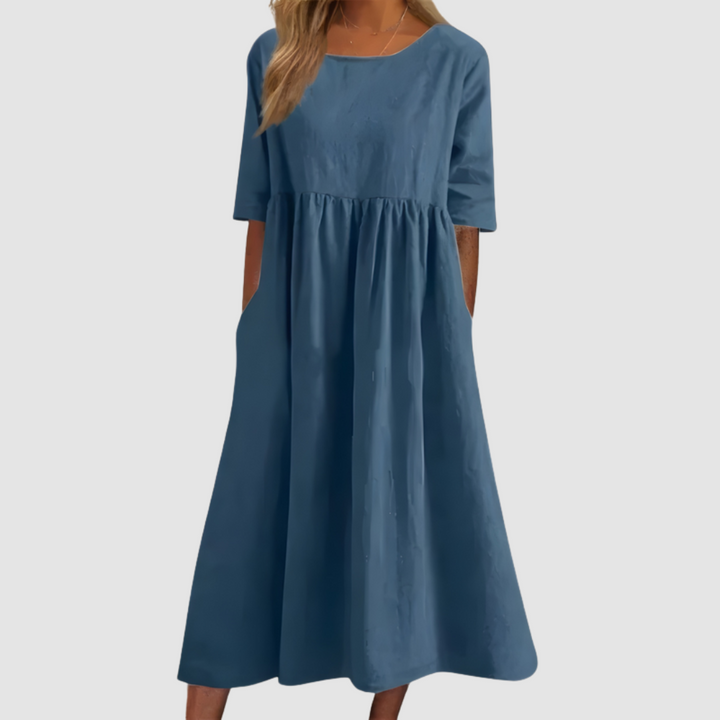 Deep blue breezy dress with elbow-length sleeves in a studio setting.