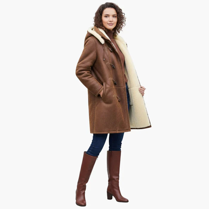 Full view of brown coat with cream interior, worn by a person. Paired with jeans and brown boots. White background.