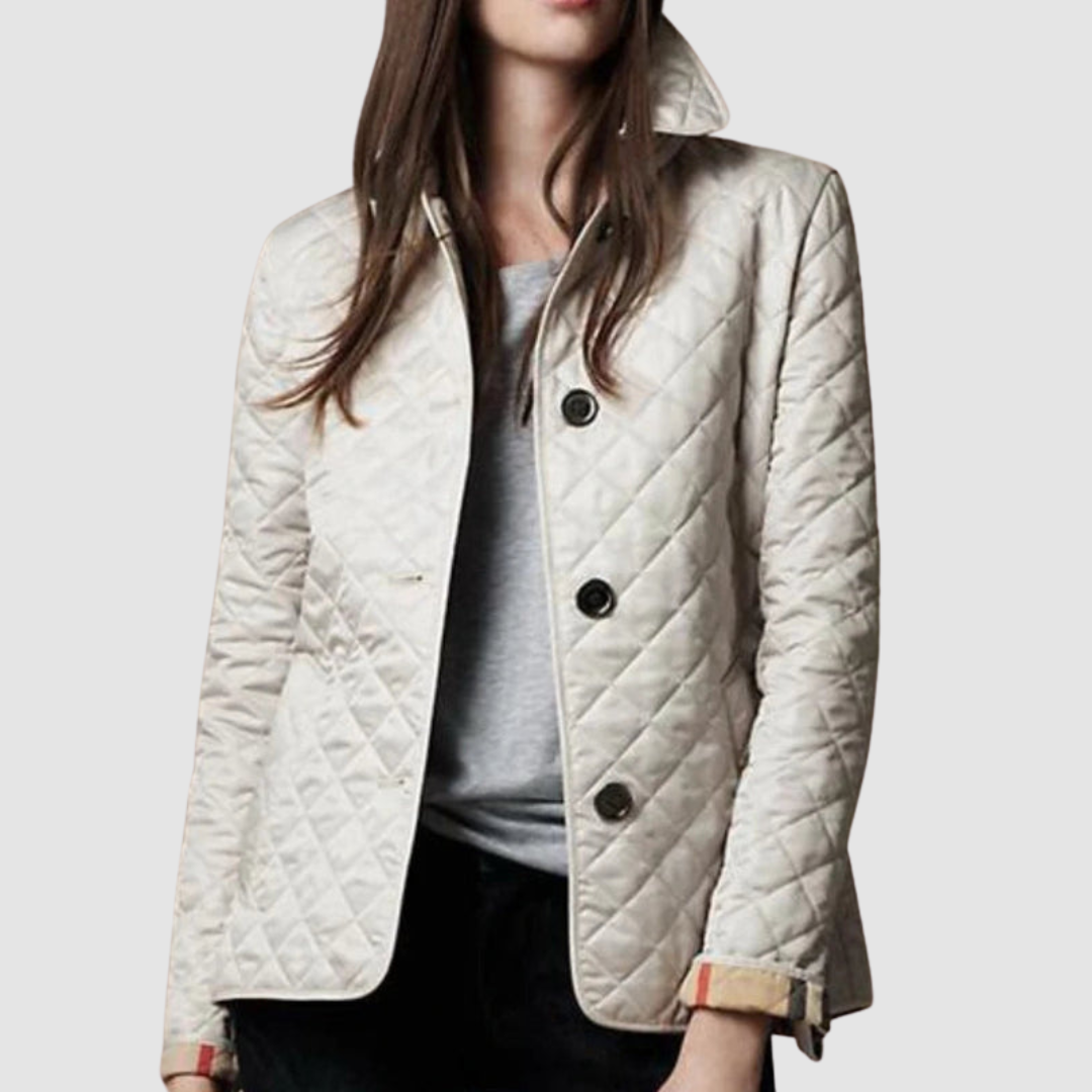 Light quilted jacket with buttons, styled over a gray top and black pants on a model, light background.