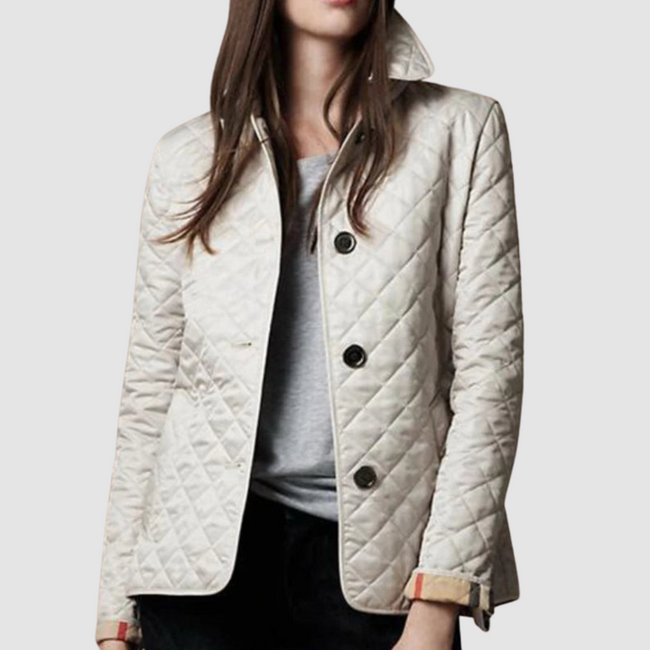 Light quilted jacket with buttons, styled over a gray top and black pants on a model, light background.