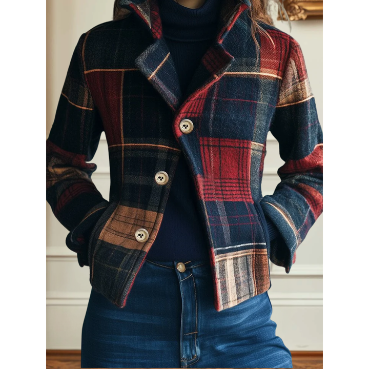 Classic plaid jacket in red and blue, buttoned up, worn over a navy turtleneck. White indoor background.
