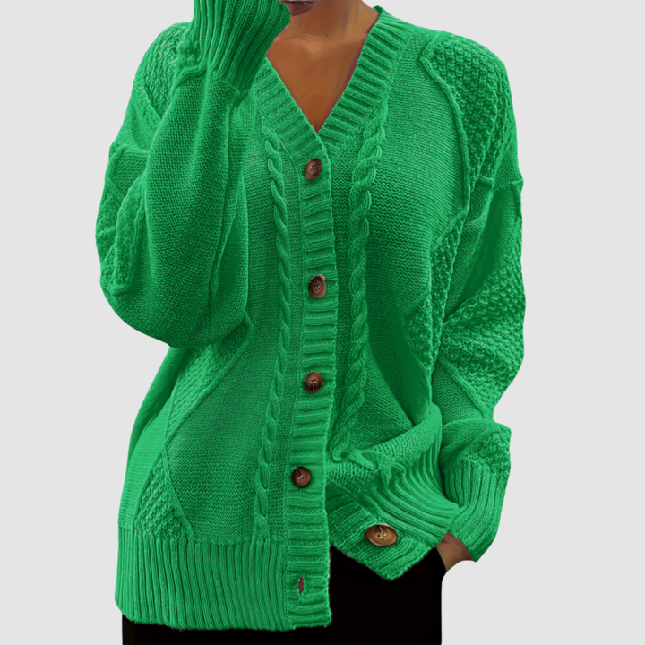Green button-up sweater with textured patterns, worn by a model; studio background.