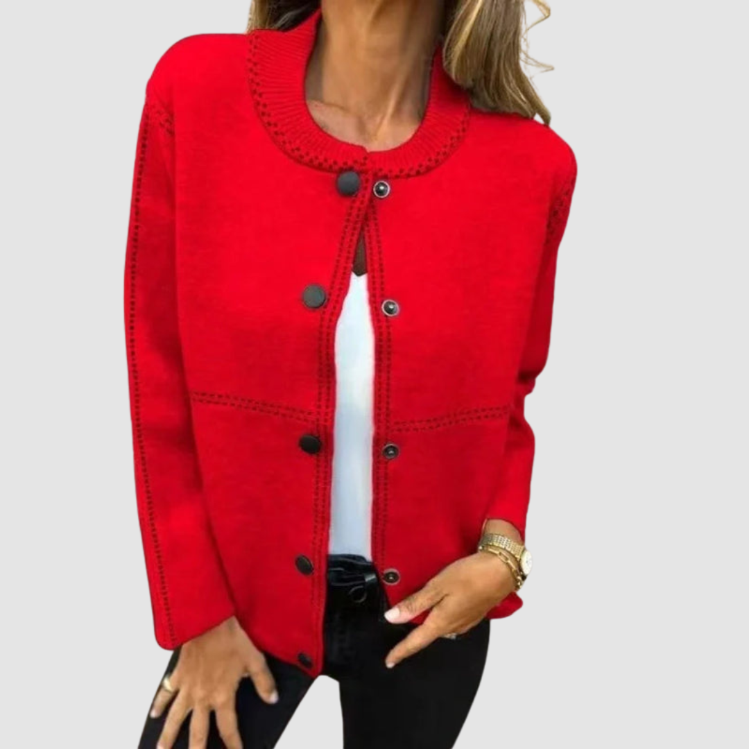 Red jacket with round collar, button closure, worn over white top and black pants in a studio setting.