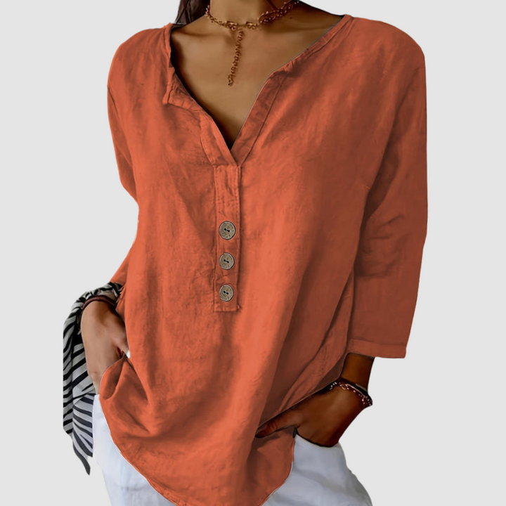 Casual rust blouse with button detail, worn by a model with a choker, against a plain background.