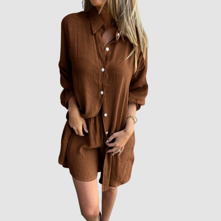 Model wearing a brown two-piece set with button-up shirt and shorts; neutral studio background.