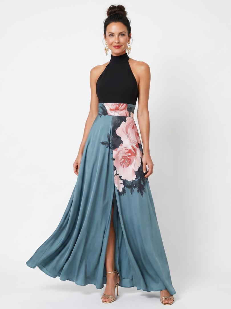 Model in a maxi dress with a black halter bodice and floral skirt at a slit, studio setting.