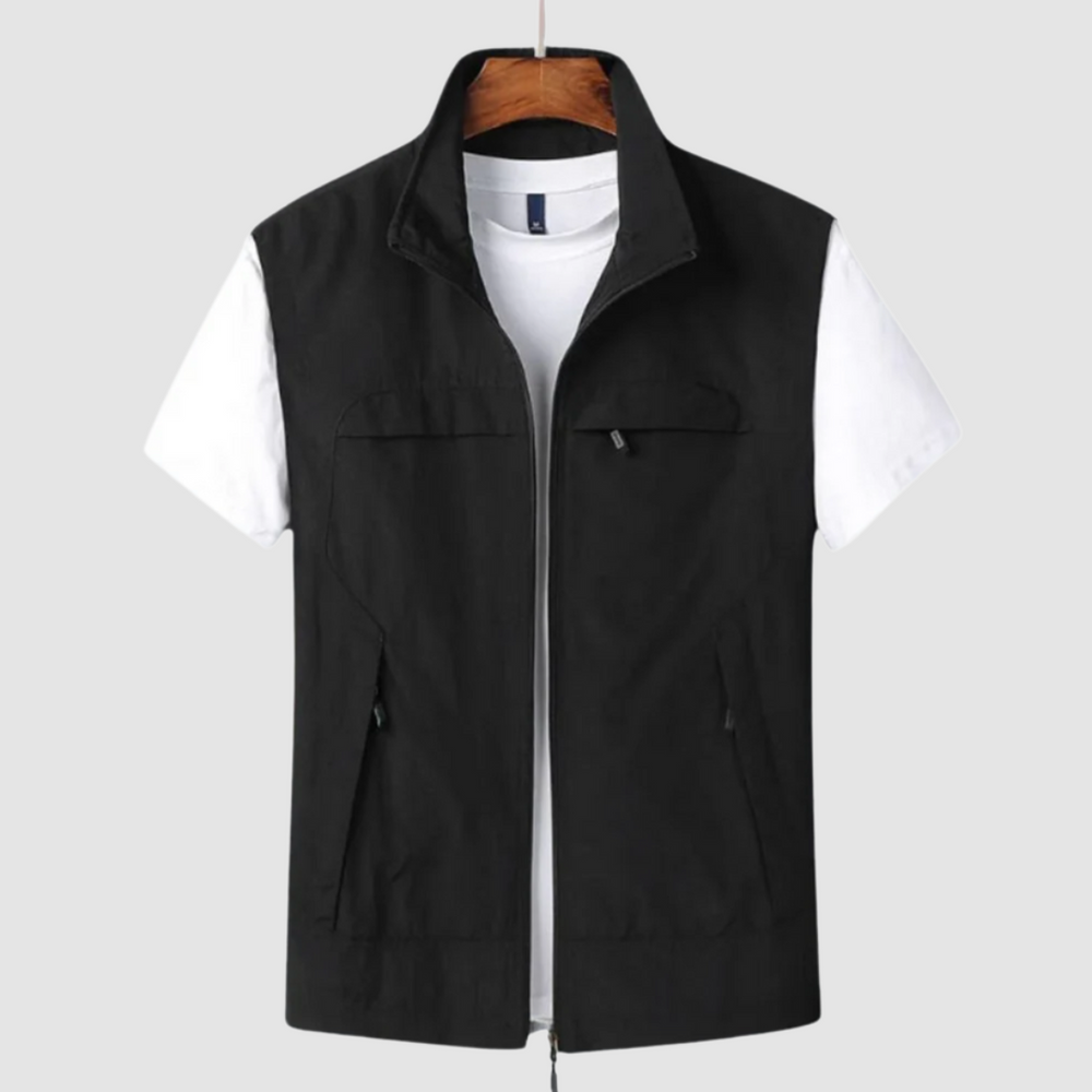 Black summer vest with zip closure and pockets, layered over a white t-shirt, on a hanger against a gray backdrop.