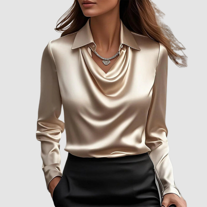 Elegant cream satin blouse with a draped neckline and long sleeves against a plain gray background.