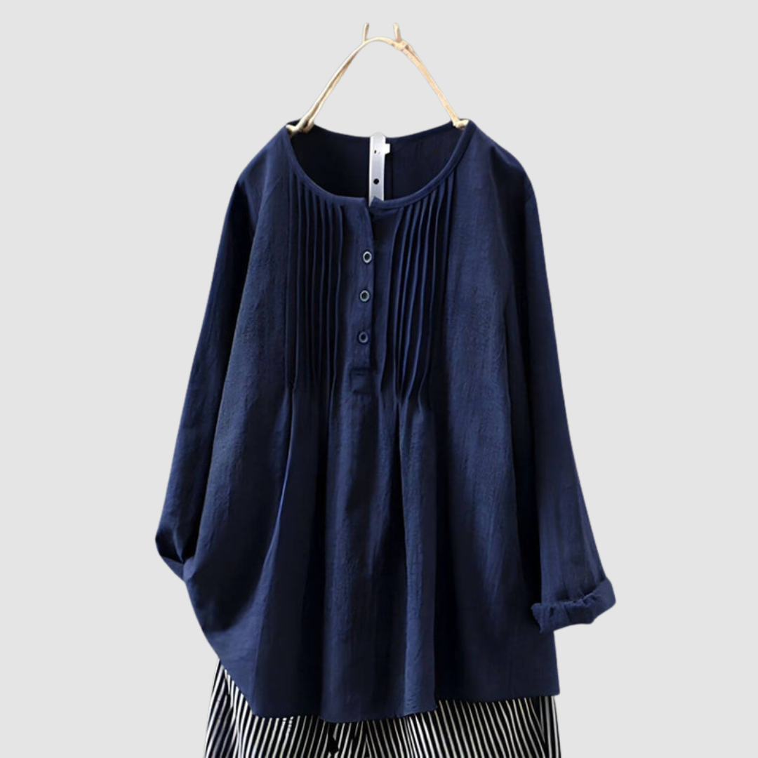 Elegant dark blue blouse with pleated front and button details, displayed on a hanger against a plain background.