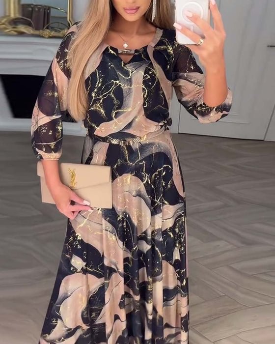 Stylish black and beige dress featuring unique print, accessorized with clutch in classy indoor setting.