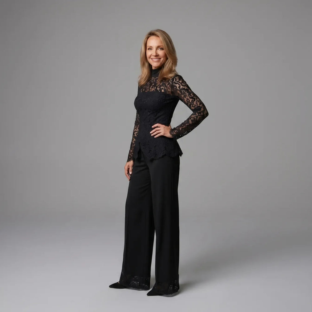 Side view of black lace jumpsuit with long sleeves, set against a gray studio background.