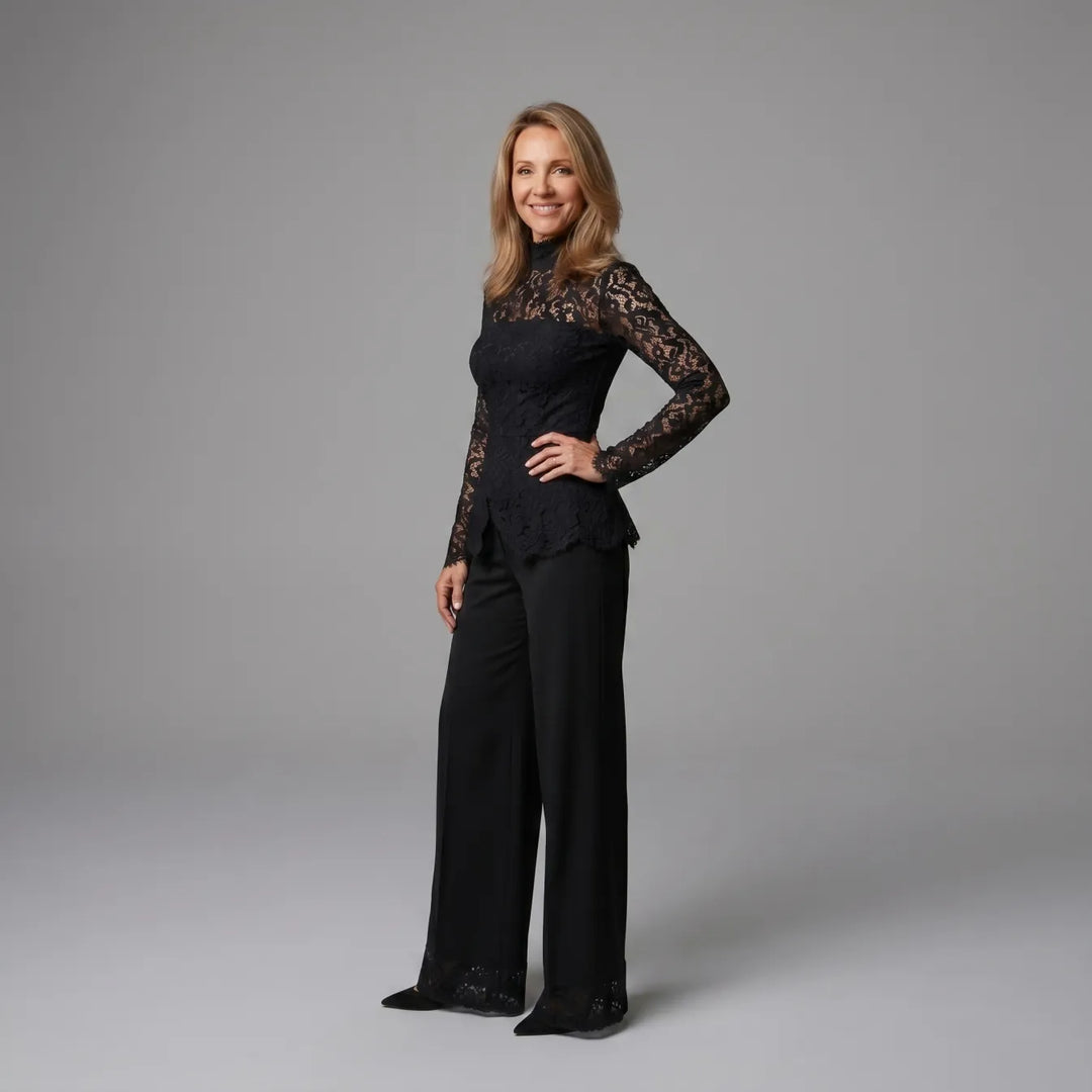 Side view of black lace jumpsuit with long sleeves, set against a gray studio background.