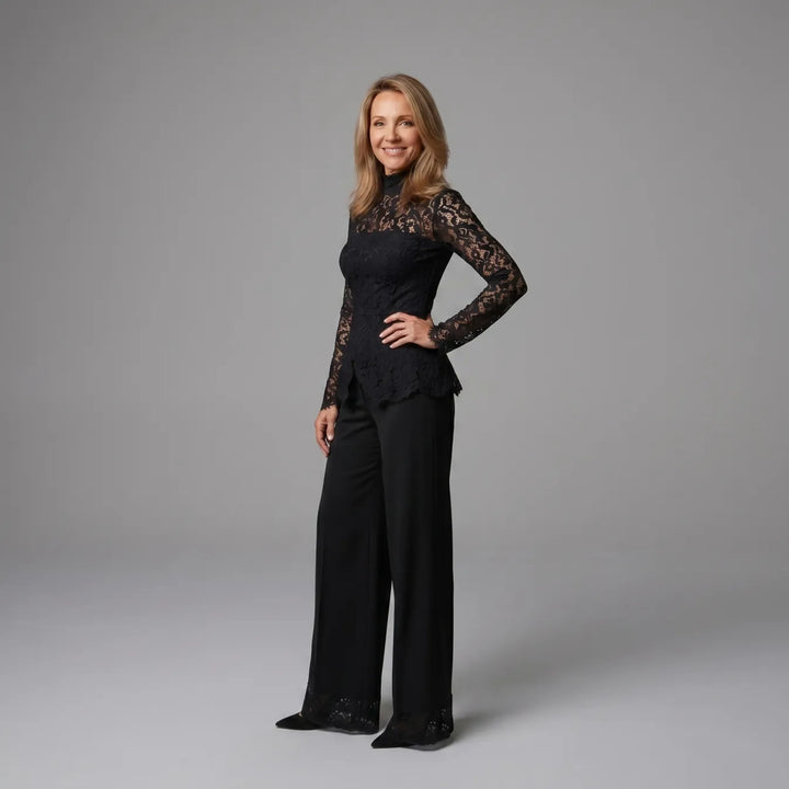 Side view of black lace jumpsuit with long sleeves, set against a gray studio background.