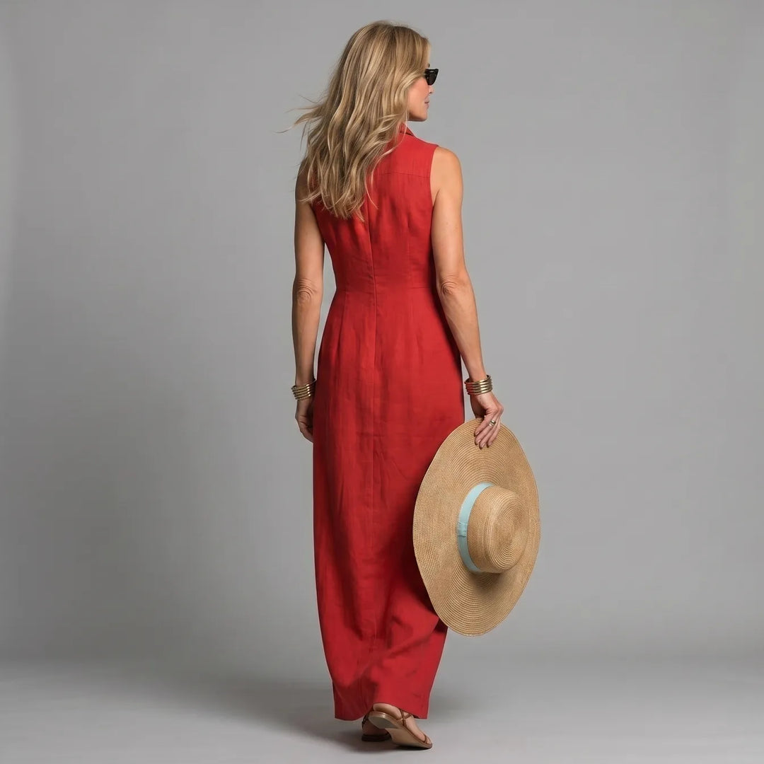 Back view of woman in red maxi shirt dress, holding a straw hat, in a studio setting.