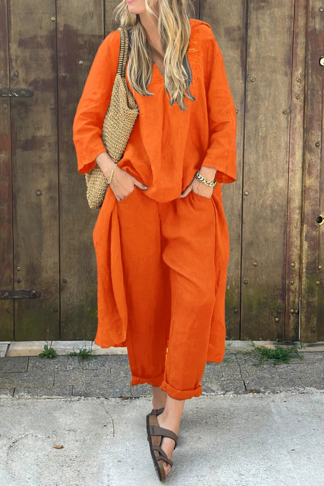 Bright orange comfortable set with woven bag against wood wall.
