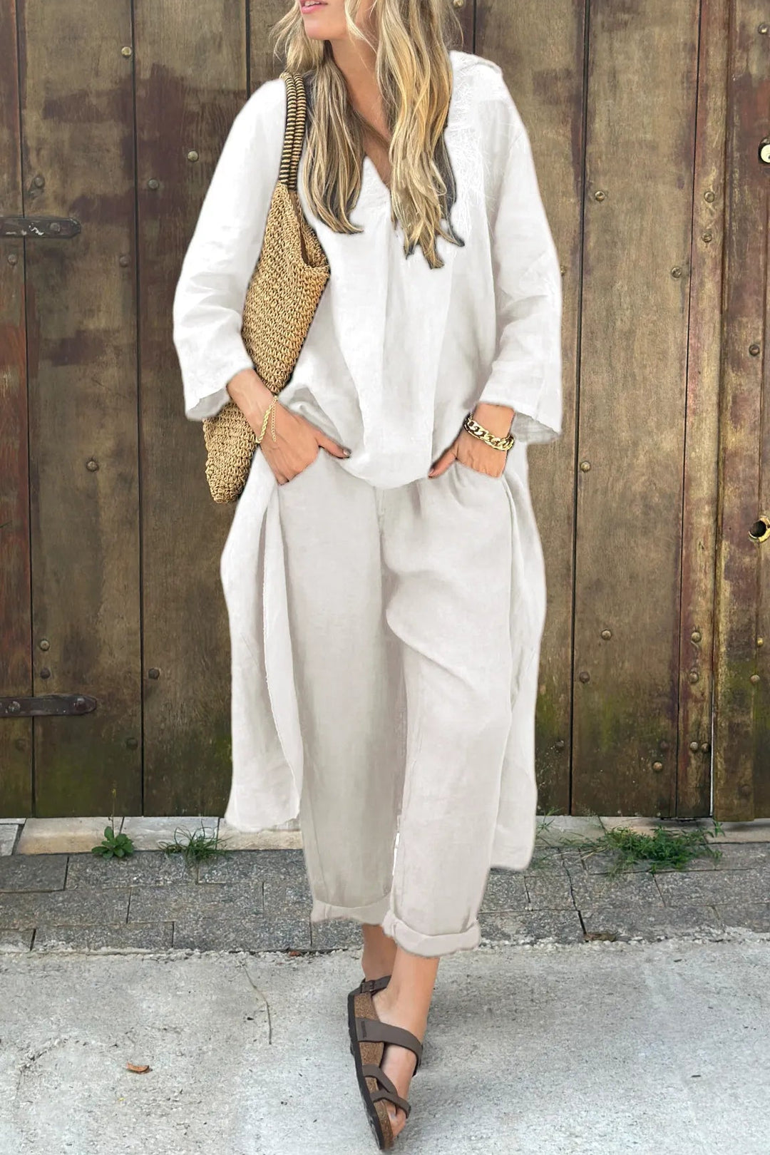 White chic outfit accessorized with woven bag in rustic setting.