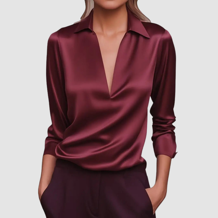 Elegant burgundy satin blouse with deep V-neck, worn in a studio setting.