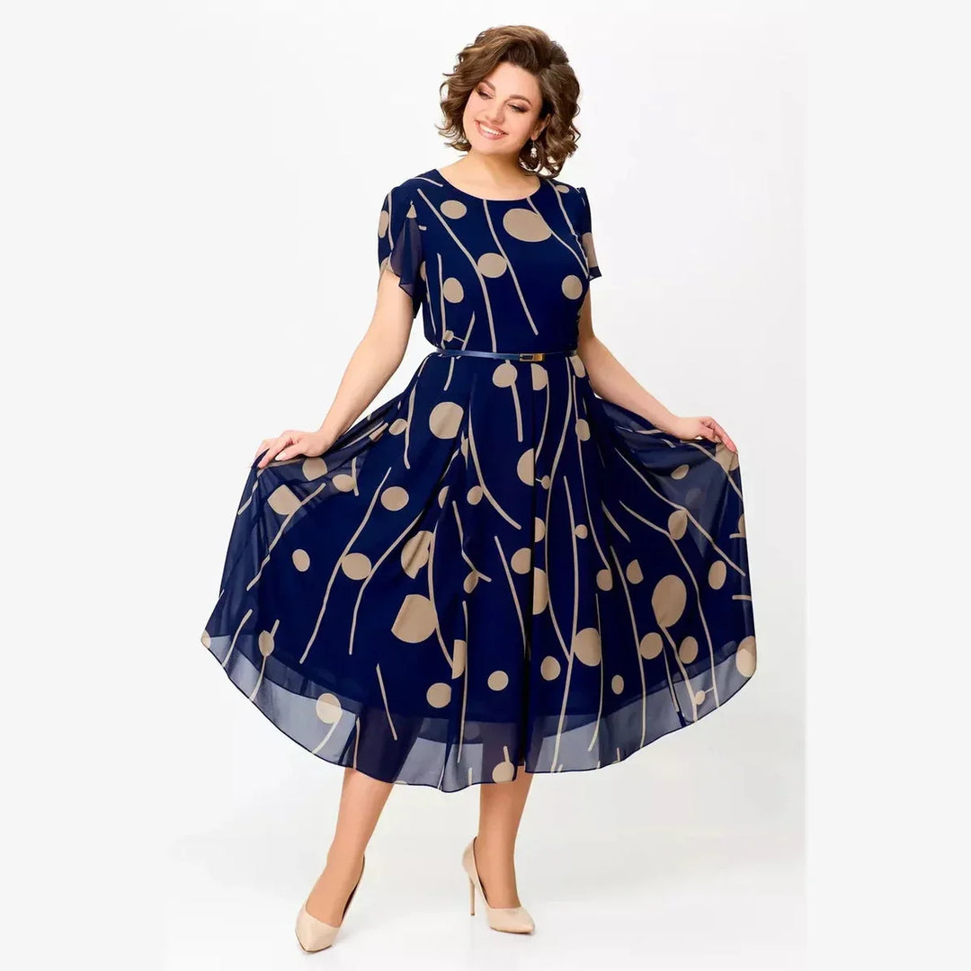 Model in navy polka dot chiffon midi dress, showcasing flowy skirt and elegant short sleeves in a studio setting.