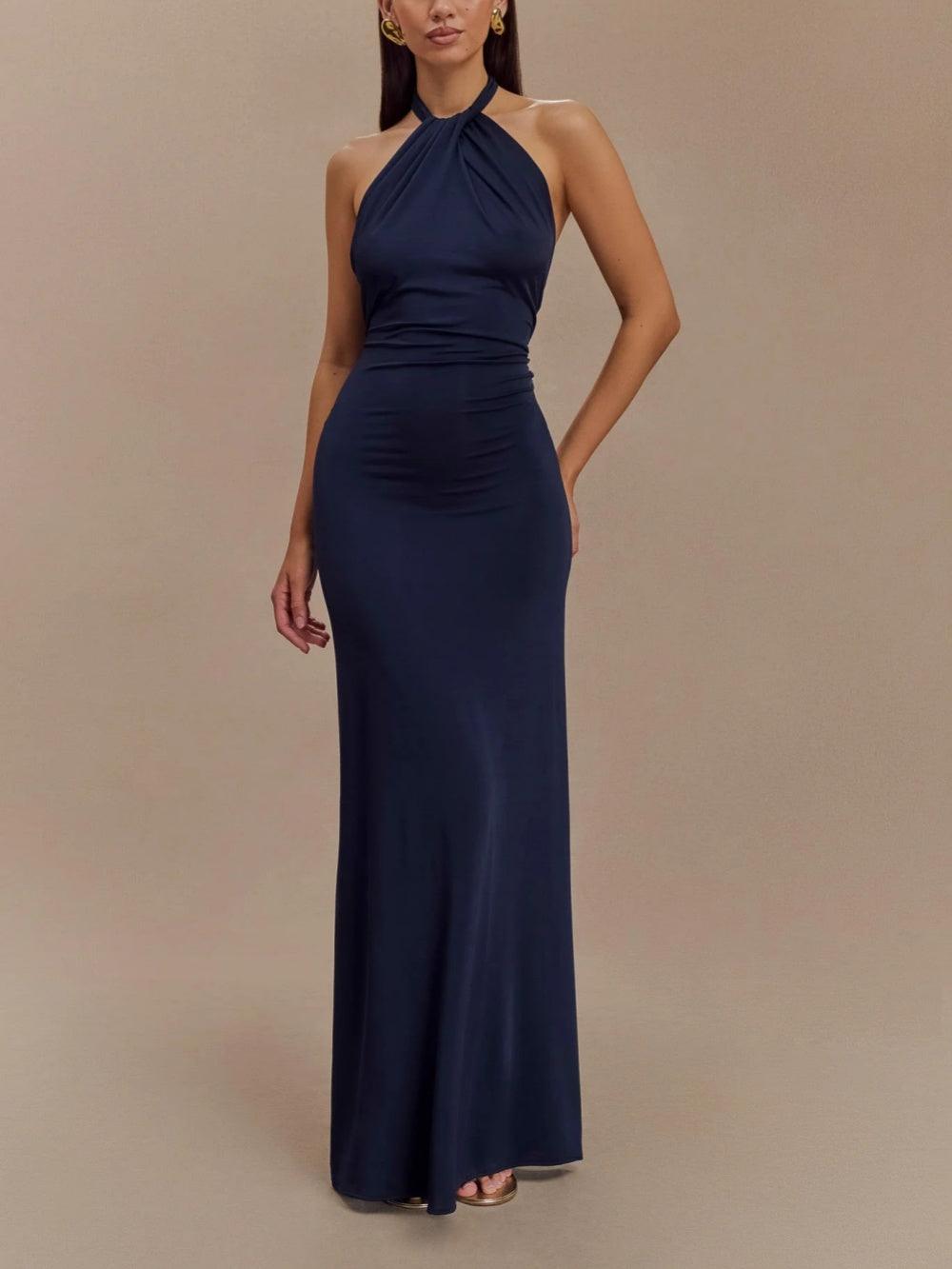 Model wearing a navy blue slinky halter maxi dress in a neutral studio setting.