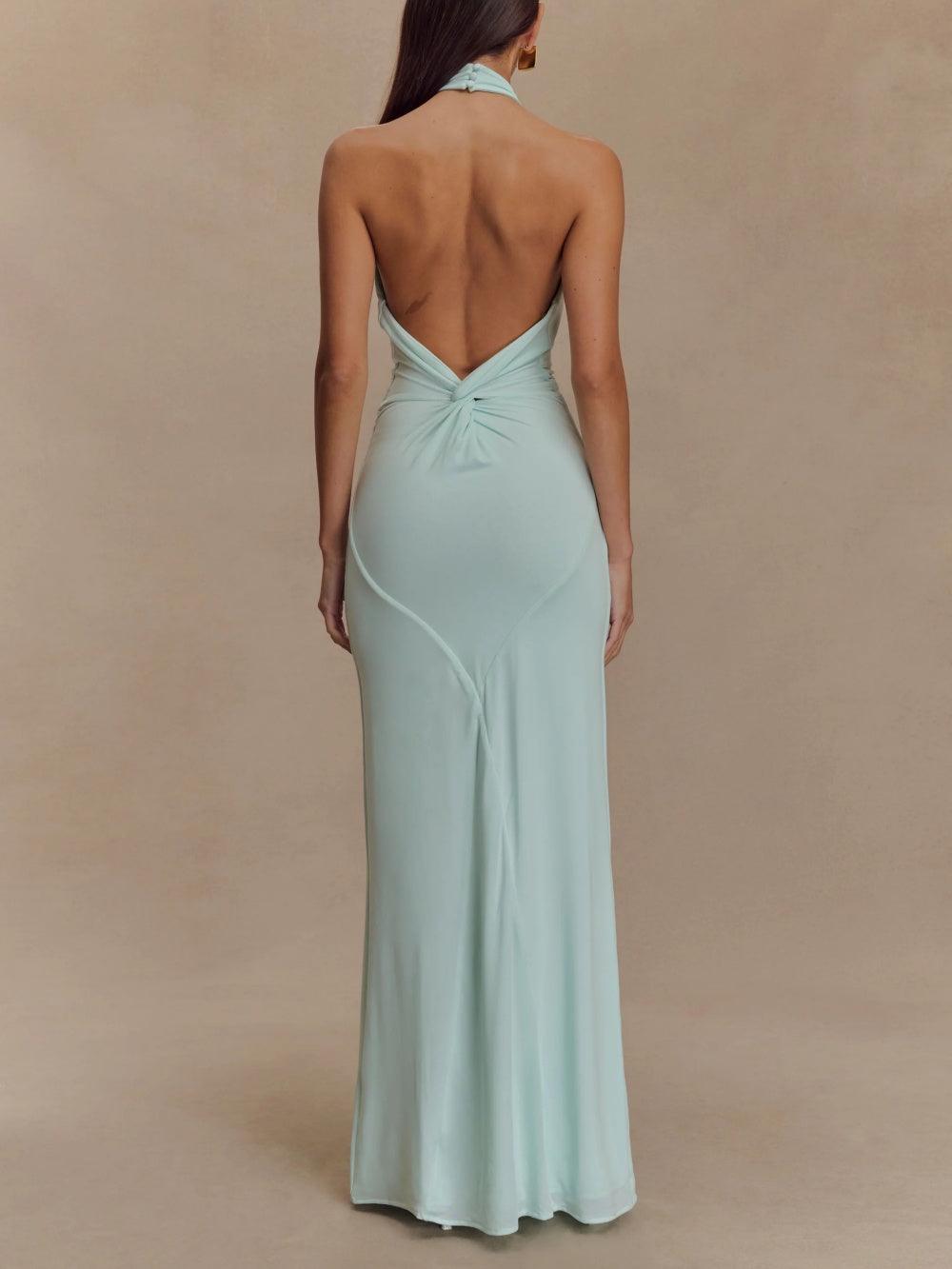 Back view of a light mint green halter maxi dress featuring a backless design in a studio setting.