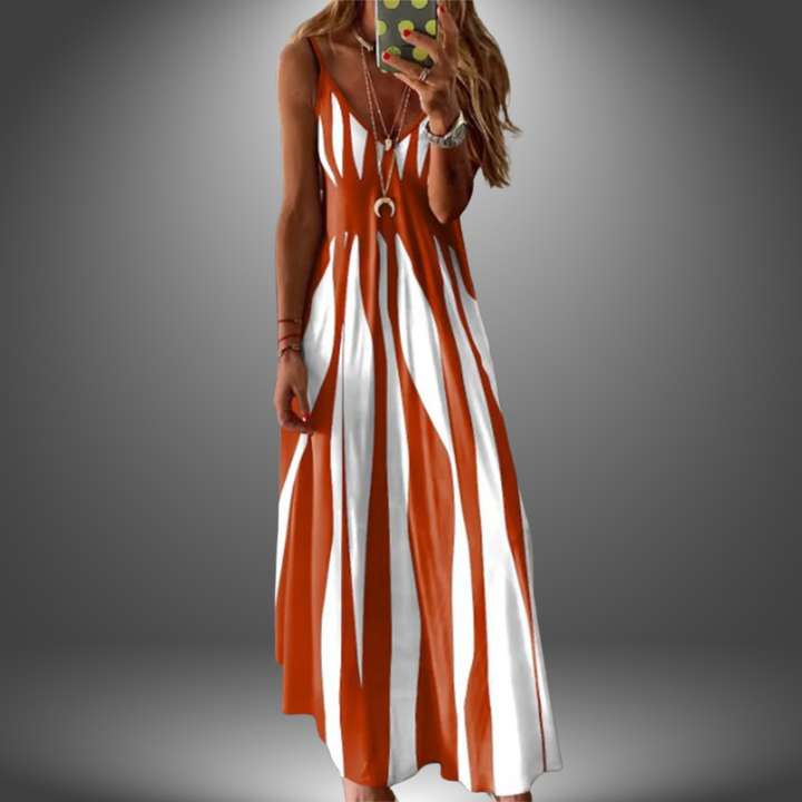 Orange and white striped long dress with a flowing design, worn by a model taking a selfie in a studio setting.