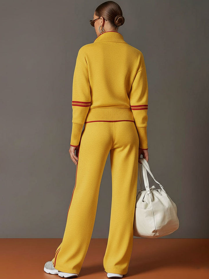 Back view of matching lounge set in yellow with contrast stripes, paired with white sneakers and a bag in a studio setting.