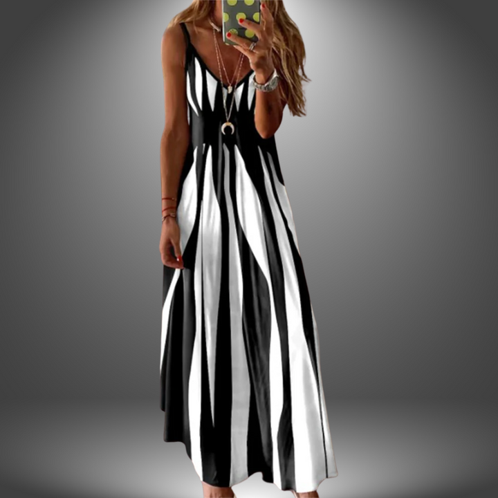 Black and white striped long dress with a flowing, casual design, worn by a model taking a selfie in a studio setting.