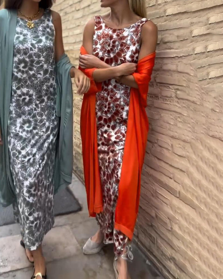 Two individuals conversing on a sidewalk, wearing floral two-piece sets with blue and red shawls.