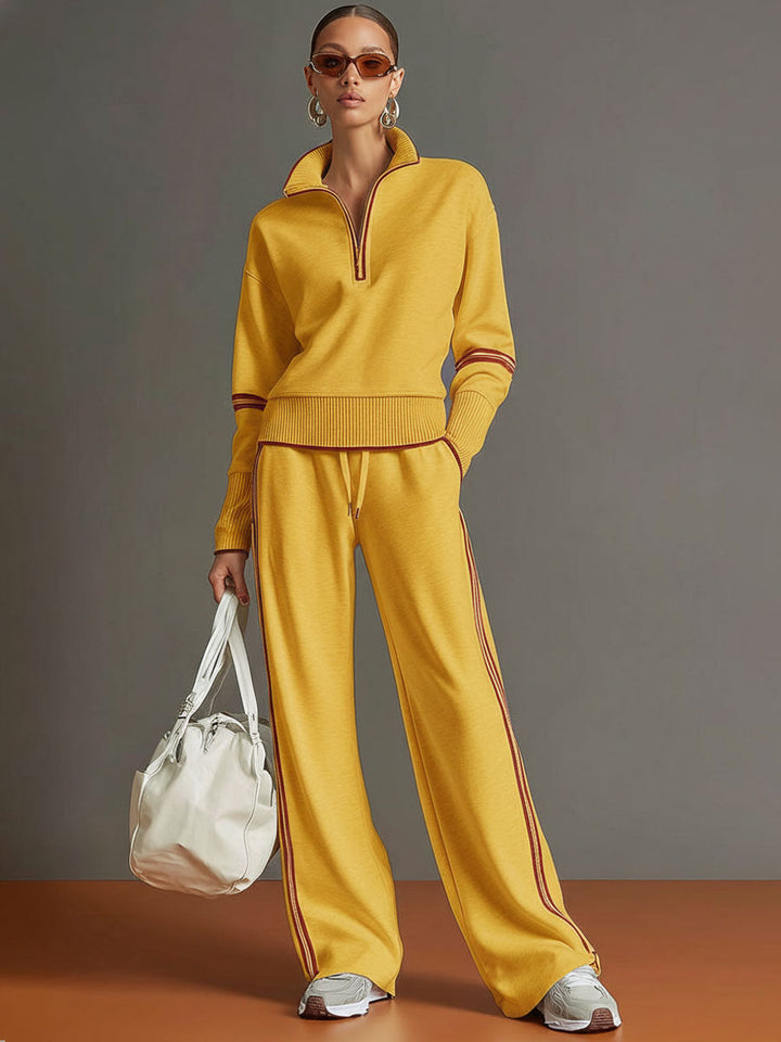 Effortless matching lounge set in yellow with contrast stripes, styled with white sneakers and a bag in a studio setting.
