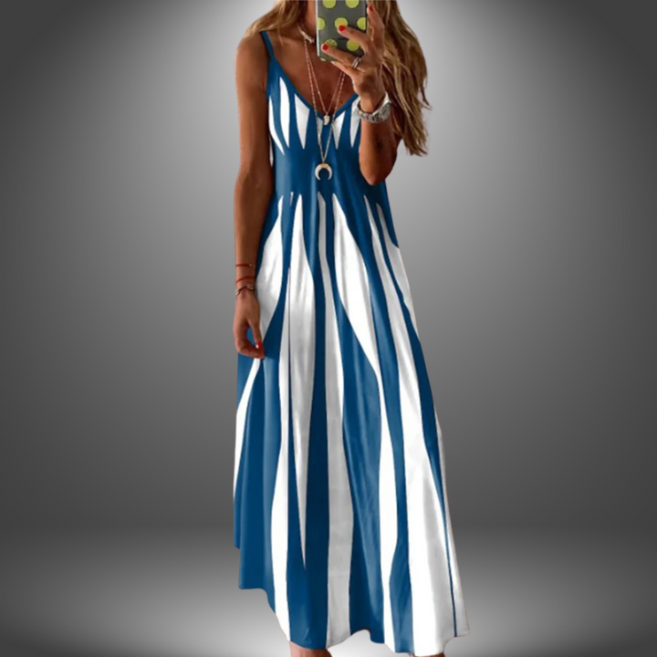 Blue and white striped long dress with a flowing design, worn by a model taking a selfie in a studio setting.