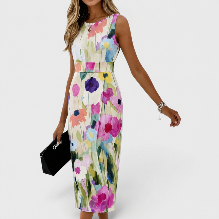 Woman wearing floral midi dress with vibrant flowers, holding black purse, studio background.
