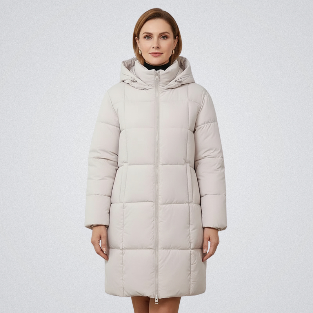Woman in a cream puffer coat with hood, standing against a plain white backdrop.