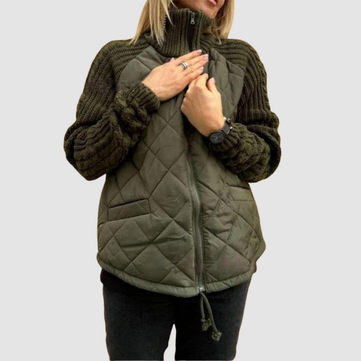 Olive green quilted jacket with knit sleeves, worn by a person in casual setting.