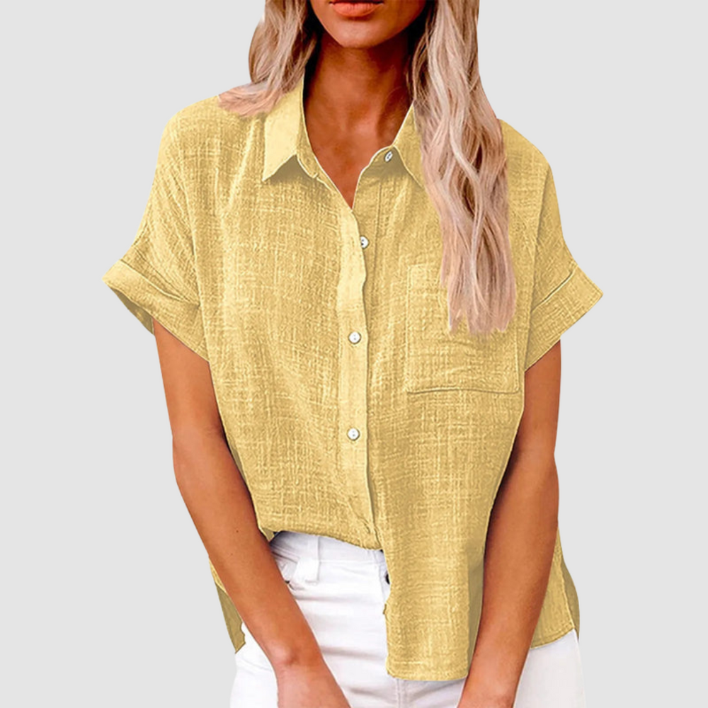 Yellow casual blouse with short sleeves and front buttons, worn in white jeans. Studio background.