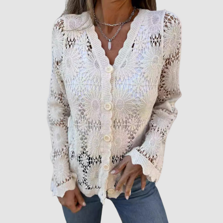 Cream lace V-neck cardigan featuring floral motifs, styled with blue jeans. Studio environment.
