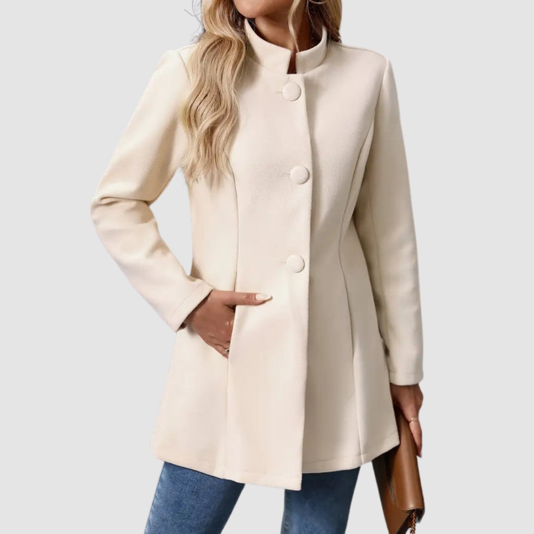Light beige jacket with large buttons, model torso view, hand in pocket, against plain background.