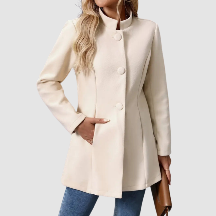 Light beige jacket with large buttons, model torso view, hand in pocket, against plain background.