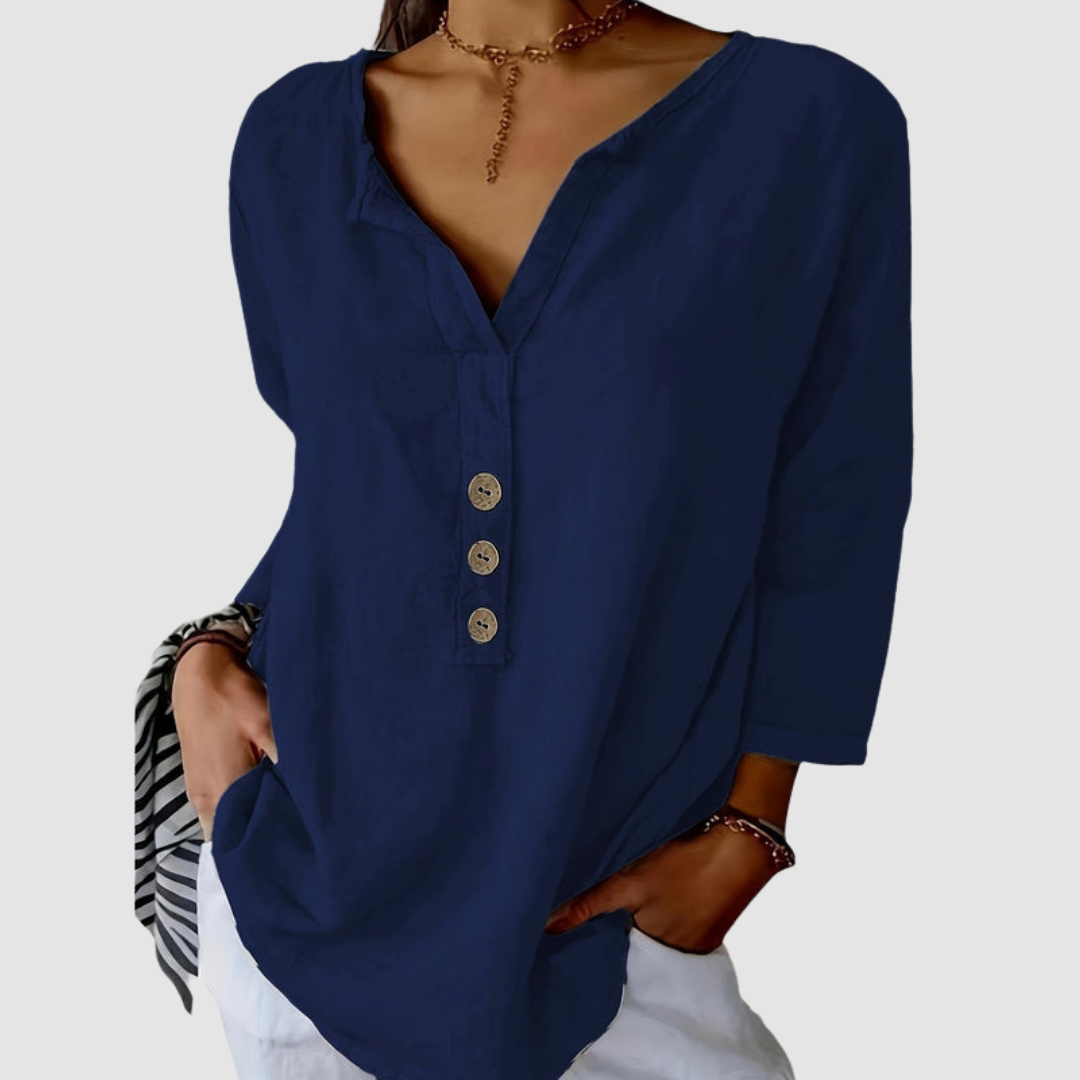 Casual navy blouse with button detail, worn by a model with a choker, against a plain background.