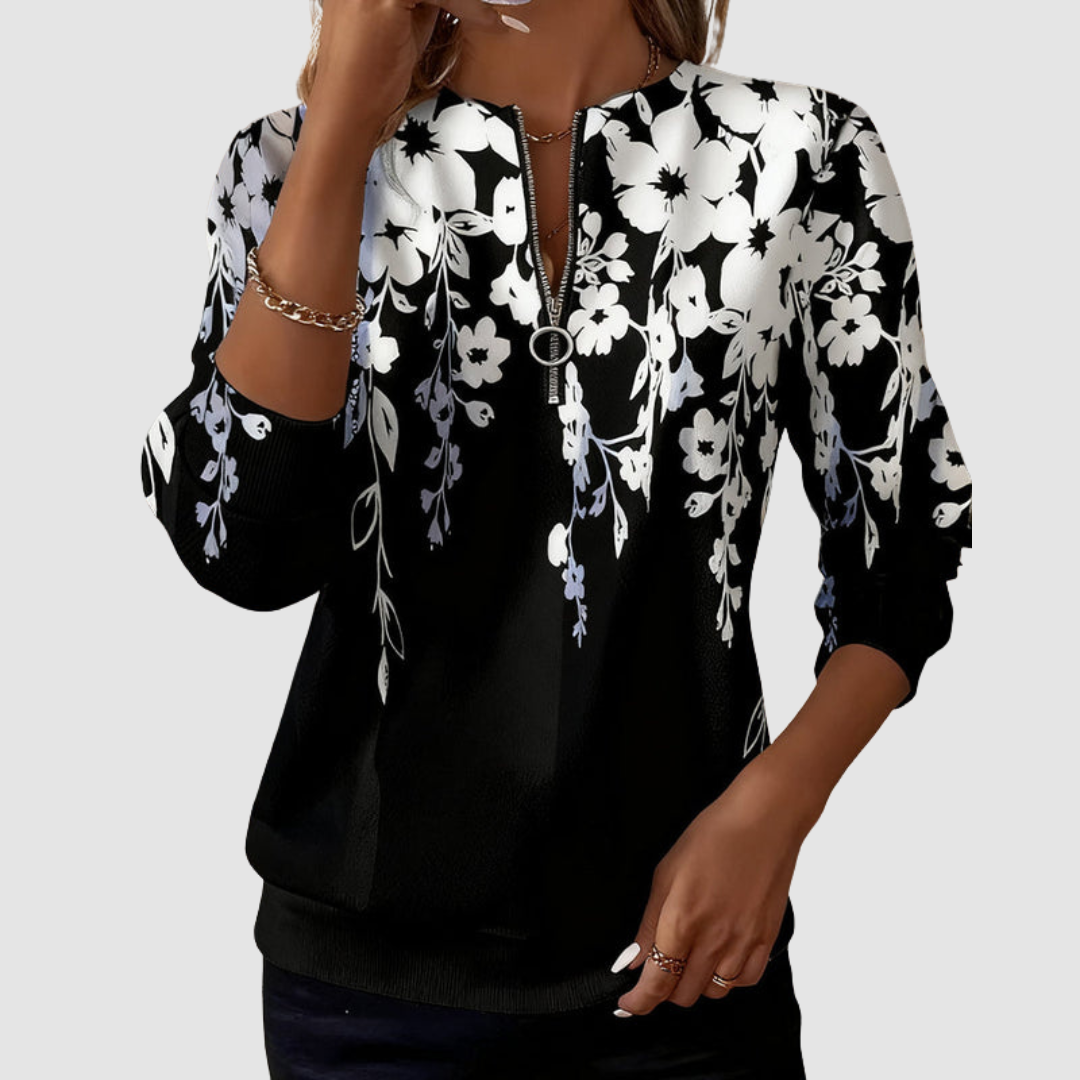 Black half zip sweatshirt with white floral pattern, worn by model in studio setting.